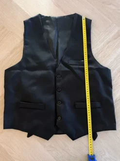 Liivi, solmio, rusetti, henkselit, taskukello ja viikset