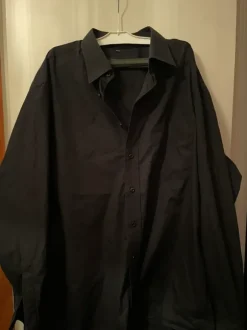 Musta kauluspaita rintataskulla