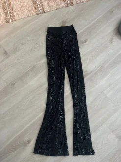 Mustat paljettihousut levenevillä lahkeilla